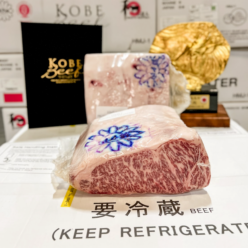 Packaged Kobe beef with decorative branding and text on a branded surface.